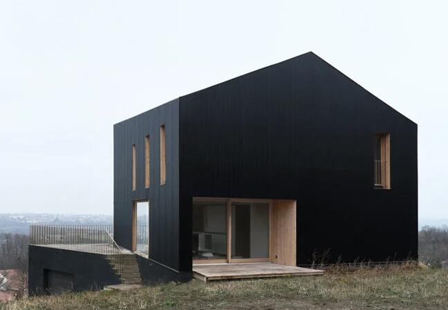 黑色波纹金属包层récita Architecture位于法国农村的细长房屋